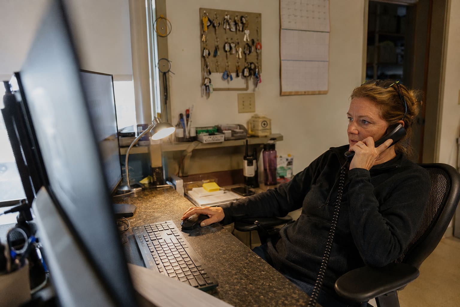 Disponentin koordiniert im Büro die Aufträge des Tages am Telefon